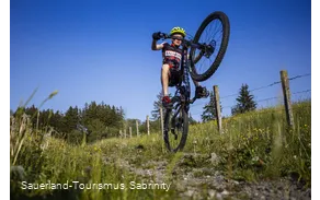 Junge auf Mountainbike akrobatisch