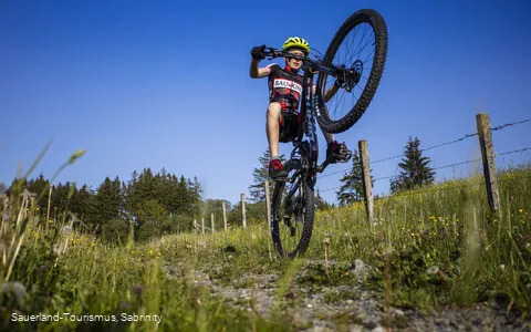 Junge auf Mountainbike akrobatisch